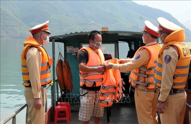 Trong ảnh: Lực lượng Cảnh sát giao thông trật tự Công an huyện Phù Yên tặng thêm áo phao chủ thuyền tại bản Vạn, xã Tân Phong. Ảnh: Quang Quyết-TTXVN