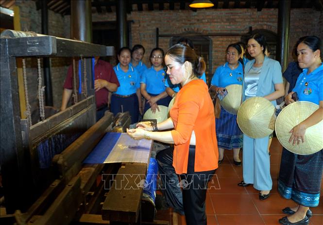 Đoàn đại biểu Hội Liên hiệp Phụ nữ Lào tham quan Làng lụa Hội An. Ảnh: Trịnh Bang Nhiệm - TTXVN