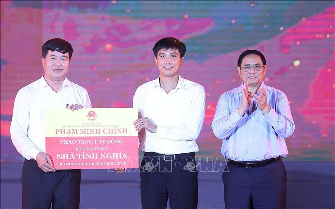 Thủ tướng Phạm Minh Chính trao cho đại diện huyện Anh Sơn kinh phí hỗ trợ xây dựng nhà tình nghĩa cho 20 gia đình thương binh, liệt sĩ. Ảnh: Dương Giang-TTXVN
