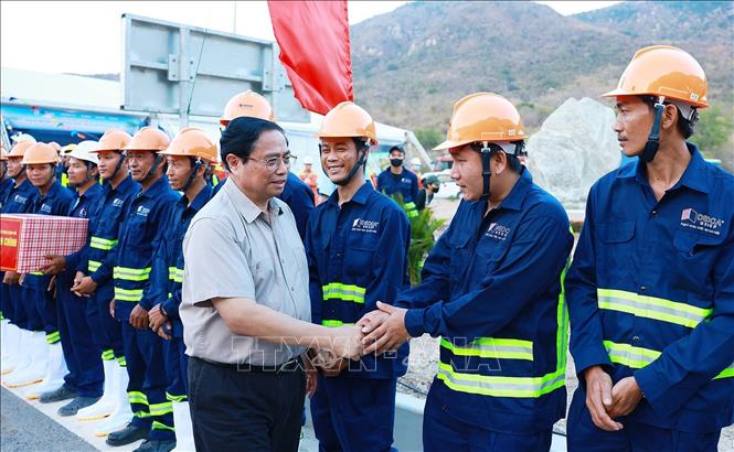 Thủ tướng Phạm Minh Chính với công nhân thi công Dự án cao tốc Cam Lâm - Vĩnh Hảo.  Ảnh: Dương Giang-TTXVN
