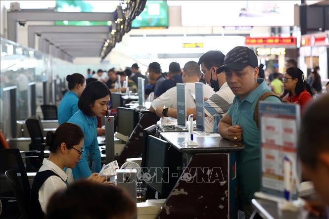 Passengers check in for Vietnam Airlines' flights at the Noi Bai International Airport. VNA Photo 